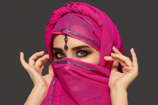 Gros plan d'une jeune femme charmante portant le hijab rose orné de paillettes et de bijoux. Style arabe . — Photo