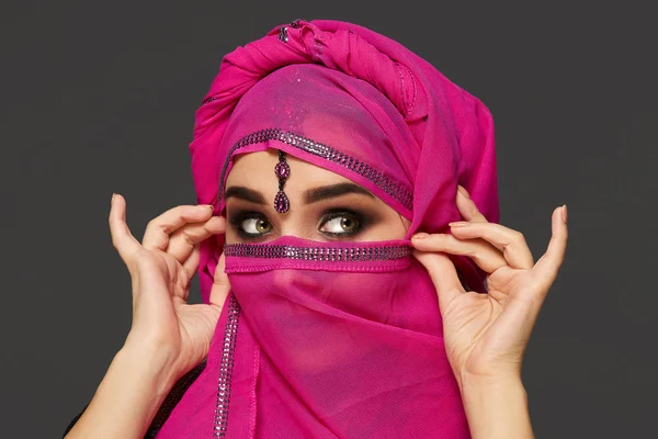 Nahaufnahme einer jungen, charmanten Frau, die den rosafarbenen Hijab trägt, der mit Pailletten und Schmuck verziert ist. arabischer Stil. — Stockfoto