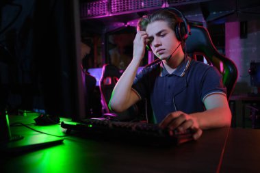 Profesyonel genç kafkas oyuncu onun Pc online oynuyor. Maçı kaybettiği için üzgün.