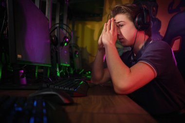 Profesyonel genç kafkas oyuncu onun Pc online oynuyor. Maçı kaybettiği için üzgün.