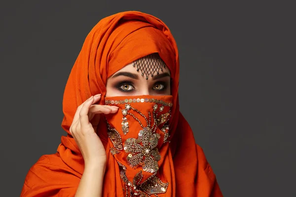 Studioaufnahme einer jungen, charmanten Frau, die den mit Pailletten und Schmuck verzierten Terrakotta-Hijab trägt. arabischer Stil. — Stockfoto
