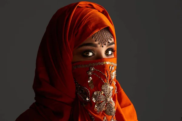 Foto de estudio de una joven encantadora mujer con el hiyab de terracota decorado con lentejuelas y joyas. Estilo árabe . — Foto de Stock