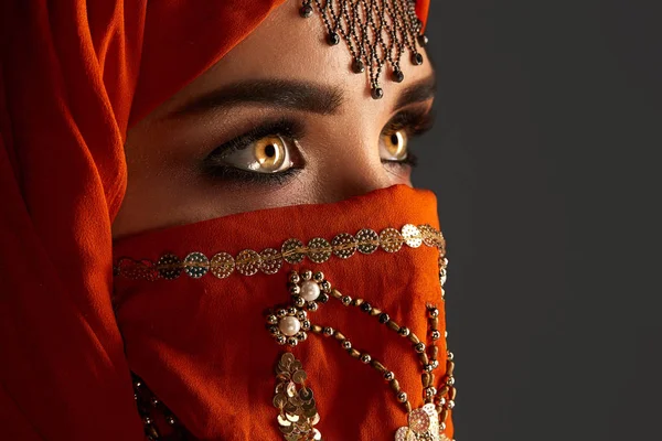 スパンコールとジュエリーで飾られたテラコッタヒジャーブを着た若い魅力的な女性のスタジオショット。アラビアスタイル. — ストック写真