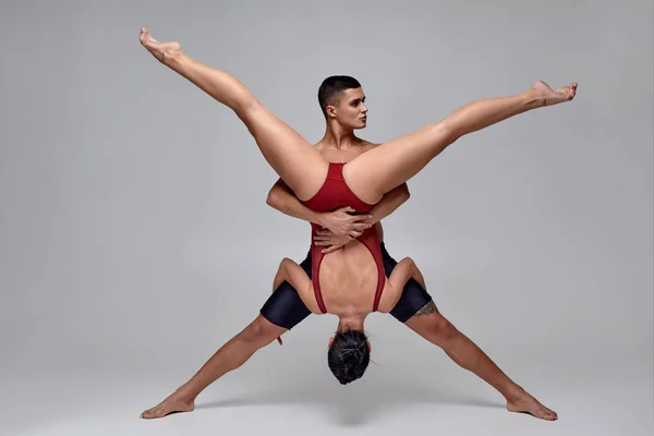 Bir atletik modern bale dansçıları çift gri bir stüdyo arka plan karşı poz. — Stok fotoğraf