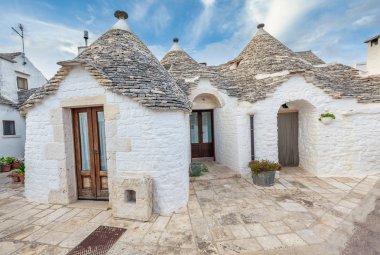 Yeşil bitki ve çiçekler arasında Trulli evleri ile Alberobello Güzel şehir, Apulia bölge, Güney İtalya.