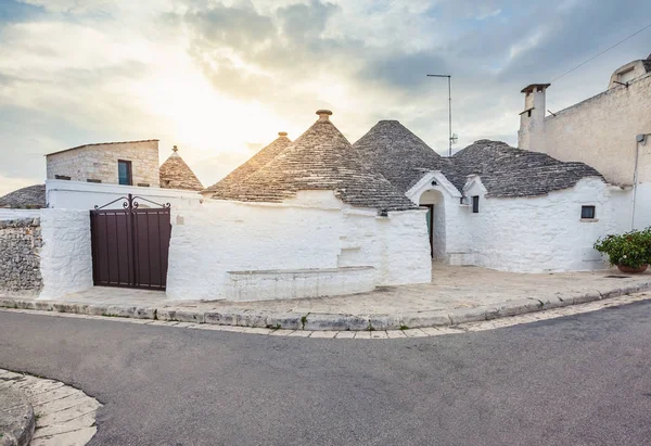 Gyönyörű Alberobello város Trulli házakkal a zöld növények és virágok között, Apulia régió, Dél-Olaszország. — Stock Fotó