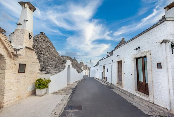 Gyönyörű Alberobello város Trulli házakkal a zöld növények és virágok között, Apulia régió, Dél-Olaszország. — Stock Fotó