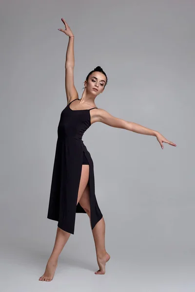 Ballerina in abito nero. Prestazioni aggraziate contemporanee su sfondo grigio . — Foto Stock