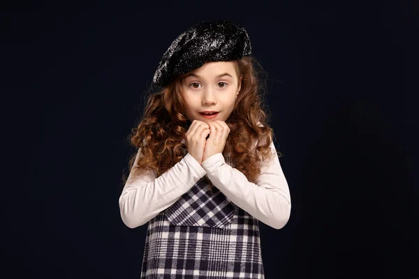 Stylish brunette kid is posing in studio on a black background. Childrens fashion. — Stock Photo, Image