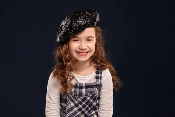 Chico morena con estilo está posando en el estudio sobre un fondo negro. Moda de niños . — Foto de Stock