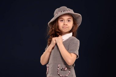 Siyah bir arka plan üzerinde poz uzun, kıvırcık saçlı güzel bir küçük çocuk Stüdyo çekim.