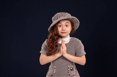 Siyah bir arka plan üzerinde poz uzun, kıvırcık saçlı güzel bir küçük çocuk Stüdyo çekim.