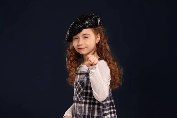 Stylish brunette kid is posing in studio on a black background. Childrens fashion. — Stock Photo, Image