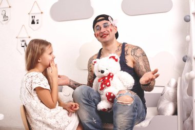Komik zaman Tattoed baba bir kap ve çocuğu evde oynuyor. Sevimli kız onun yatak odasında babasına makyaj yapıyor. Aile tatili birlikteliği