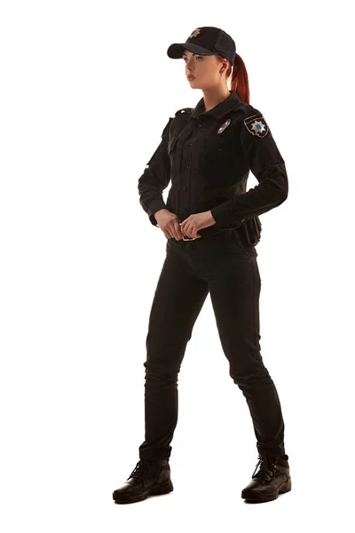 흰색 배경에 고립 된 카메라를 위해 포즈를 취하는 빨간 머리의 여성 경찰관의 전체 길이 샷. — 스톡 사진