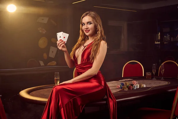 Joven hermosa mujer está posando contra una mesa de póquer en casino de lujo . — Foto de Stock