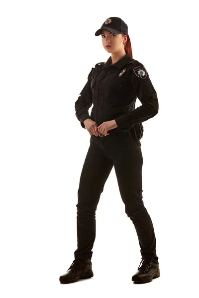 Full length shot of a redheaded female police officer posing for the camera isolated on white background. — Stock Photo, Image