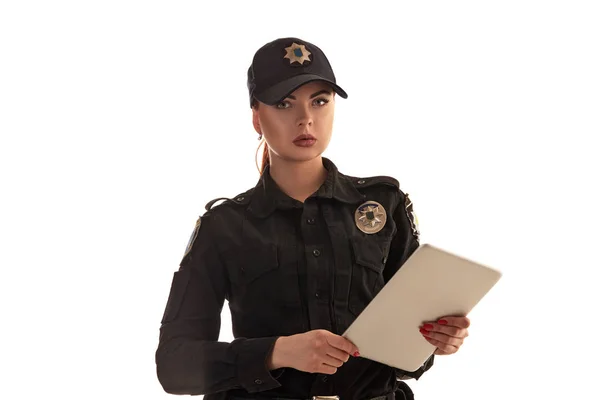 Close-up shot of a redheaded female police officer posing for the camera isolated on white background. — Stock Photo, Image