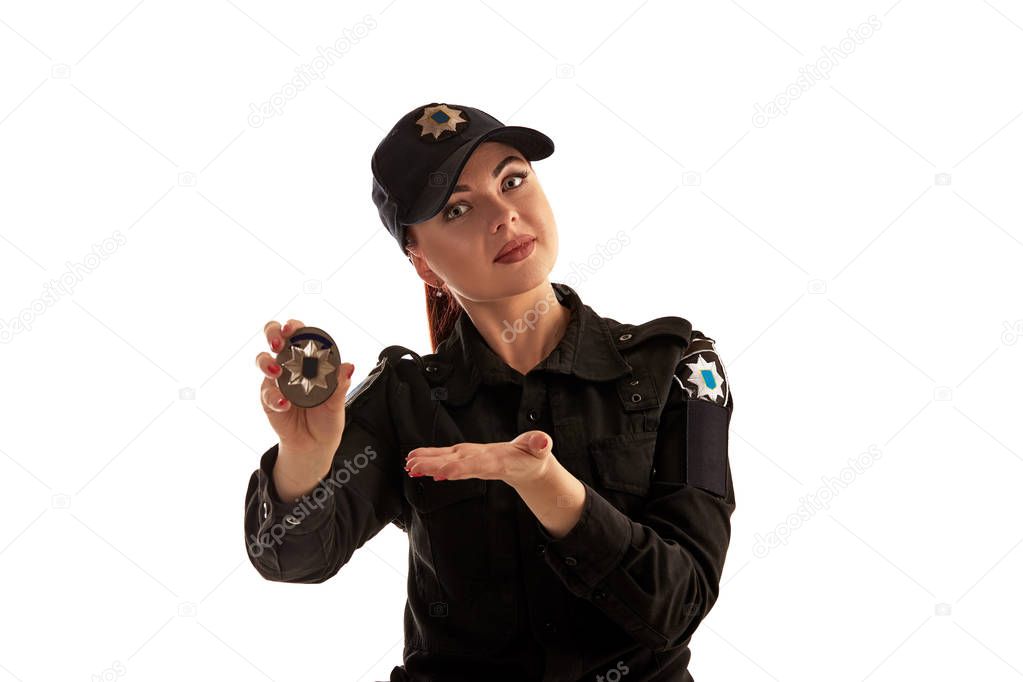 Close-up shot of a redheaded female police officer posing for the camera isolated on white background.