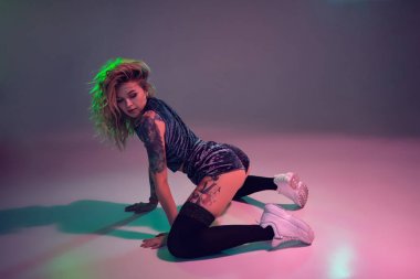 velour mavi ganimet şort ve siyah çorap pembe arka plan üzerinde dizlerinin üzerinde twerk dans güzel kafkas sarışın kız