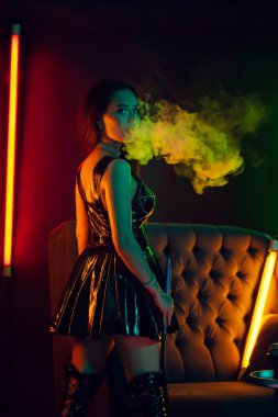 Seksi esmer model lüks bir gece kulübünde bir duman nefes bir nargile içiyor.