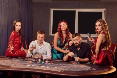 Genç ve zengin bir grup kumarhanede poker oynuyor..