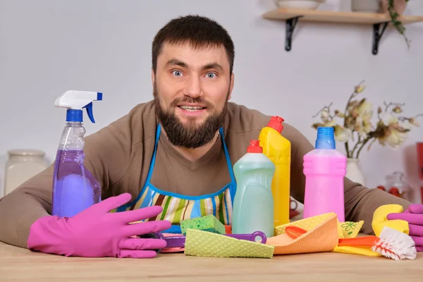 Giovane uomo barbuto bello in cucina, mostra tutto il suo personale di pulizia detergenti, spazzole, spray. Pensa di essere pronto per una vera pulizia. — Foto Stock