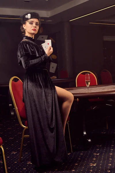 Молодая замечательная женщина позирует против покерного стола в роскошном казино . — стоковое фото