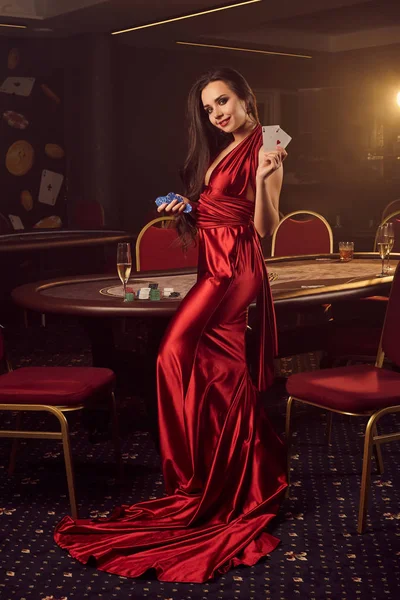 Jonge charmante vrouw poseert aan een pokertafel in vip casino. — Stockfoto