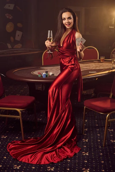 Jonge charmante vrouw poseert aan een pokertafel in vip casino. — Stockfoto