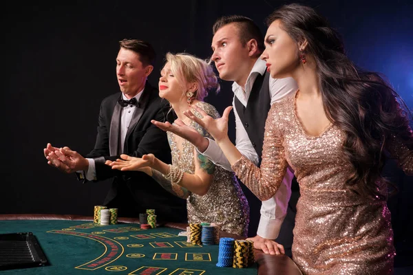 Grupo de amigos ricos con estilo están jugando al poker en el casino . — Foto de Stock