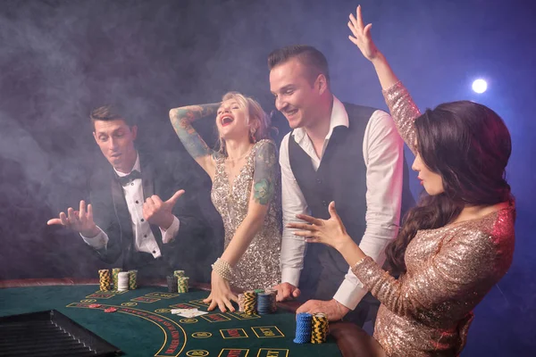 Ομάδα από ένα κομψό πλούσιους φίλους παίζουν πόκερ στο καζίνο. — Φωτογραφία Αρχείου