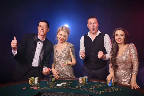 スタイリッシュな裕福な友人のグループがカジノでポーカーをプレイしています。. — ストック写真