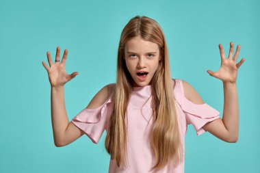 Mavi bir arka plan üzerinde poz pembe bir t-shirt güzel bir kız sarışın genç Stüdyo portresi.