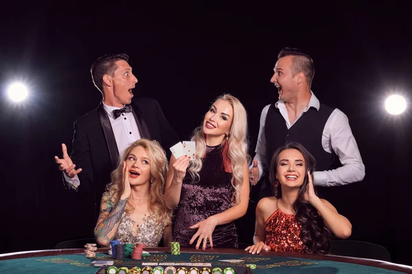 Skupina stylových bohatých přátel hrají poker v kasinu. — Stock fotografie