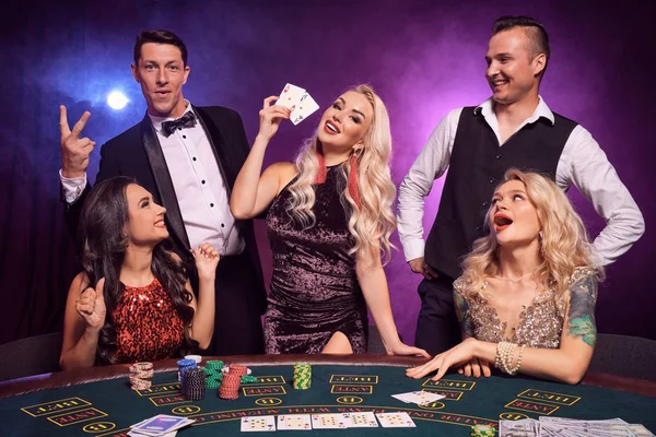 Skupina mladých bohatých přátel hrají poker v kasinu. — Stock fotografie