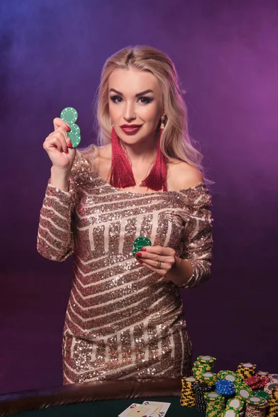 Blonde vrouw met een perfecte kapsel en heldere make-up is poseren met gokchips in haar handen. Casino, Poker. — Stockfoto