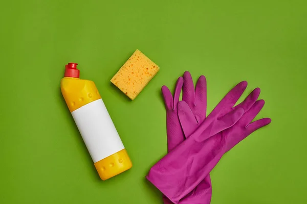 Detergents and cleaning accessories on a green background. Housekeeping concept. — Stock Photo, Image