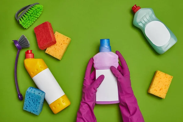 Detergentes e acessórios de limpeza em um fundo verde. Conceito de serviço de limpeza . — Fotografia de Stock