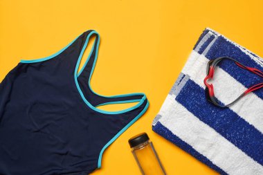 Sarı bir arka plan üzerinde düz yatıyordu yaz havuzu aksesuarları. Renkli plaj giyimi.