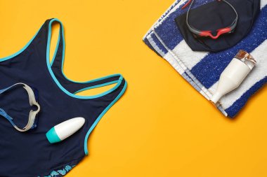 Sarı bir arka plan üzerinde düz yatıyordu yaz havuzu aksesuarları. Renkli plaj giyimi.