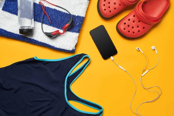 Sarı bir arka plan üzerinde düz yatıyordu yaz havuzu aksesuarları. Renkli plaj giyimi.