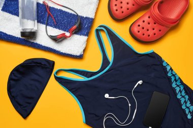 Sarı bir arka plan üzerinde düz yatıyordu yaz havuzu aksesuarları. Renkli plaj giyimi.