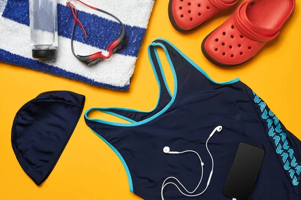 Sarı bir arka plan üzerinde düz yatıyordu yaz havuzu aksesuarları. Renkli plaj giyimi.