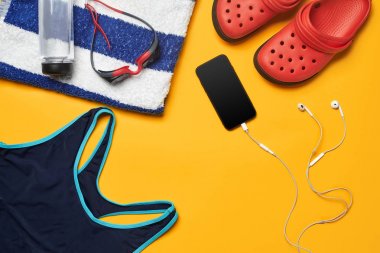 Sarı bir arka plan üzerinde düz yatıyordu yaz havuzu aksesuarları. Renkli plaj giyimi.