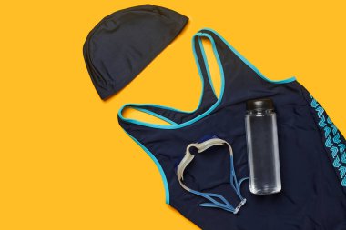 Sarı bir arka plan üzerinde düz yatıyordu yaz havuzu aksesuarları. Renkli plaj giyimi.