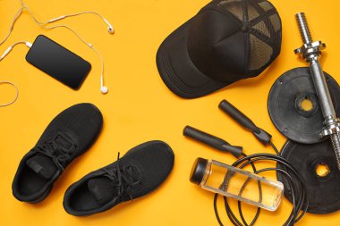 Sarı bir arka plan üzerinde bir spor salonu aksesuarları yakın çekim stüdyo çekimi. Üst görünüm, düz yatıyordu.