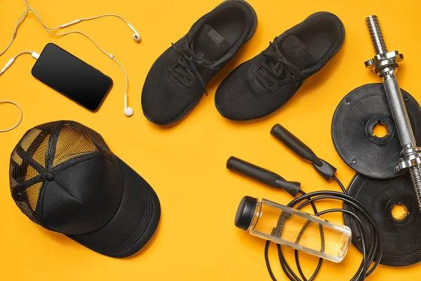 Sarı bir arka plan üzerinde bir spor salonu aksesuarları yakın çekim stüdyo çekimi. Üst görünüm, düz yatıyordu.