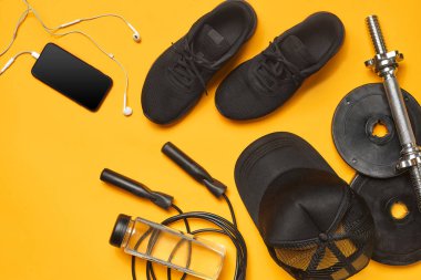 Sarı bir arka plan üzerinde bir spor salonu aksesuarları yakın çekim stüdyo çekimi. Üst görünüm, düz yatıyordu.