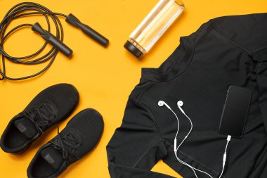 Sarı bir arka plan üzerinde bir spor salonu aksesuarları yakın çekim stüdyo çekimi. Üst görünüm, düz yatıyordu.